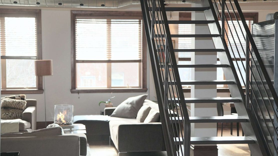 salon moderne avec un escalier métalique au premier plan