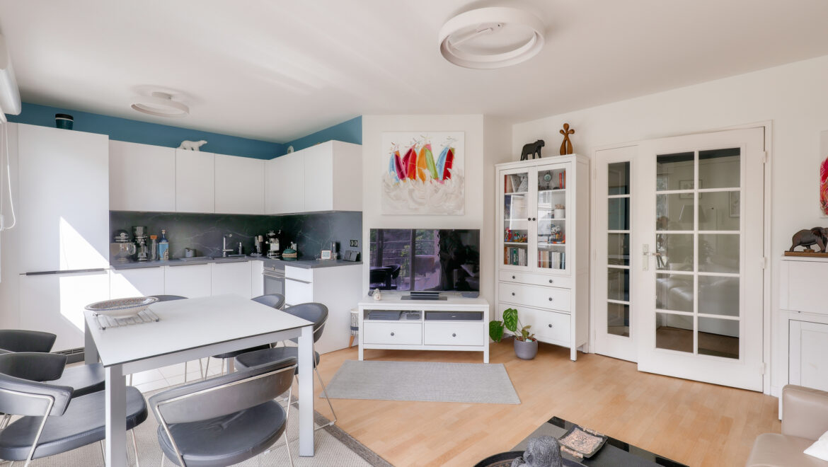 Salon moderne avec cuisine ouverte et mobilier contemporain.