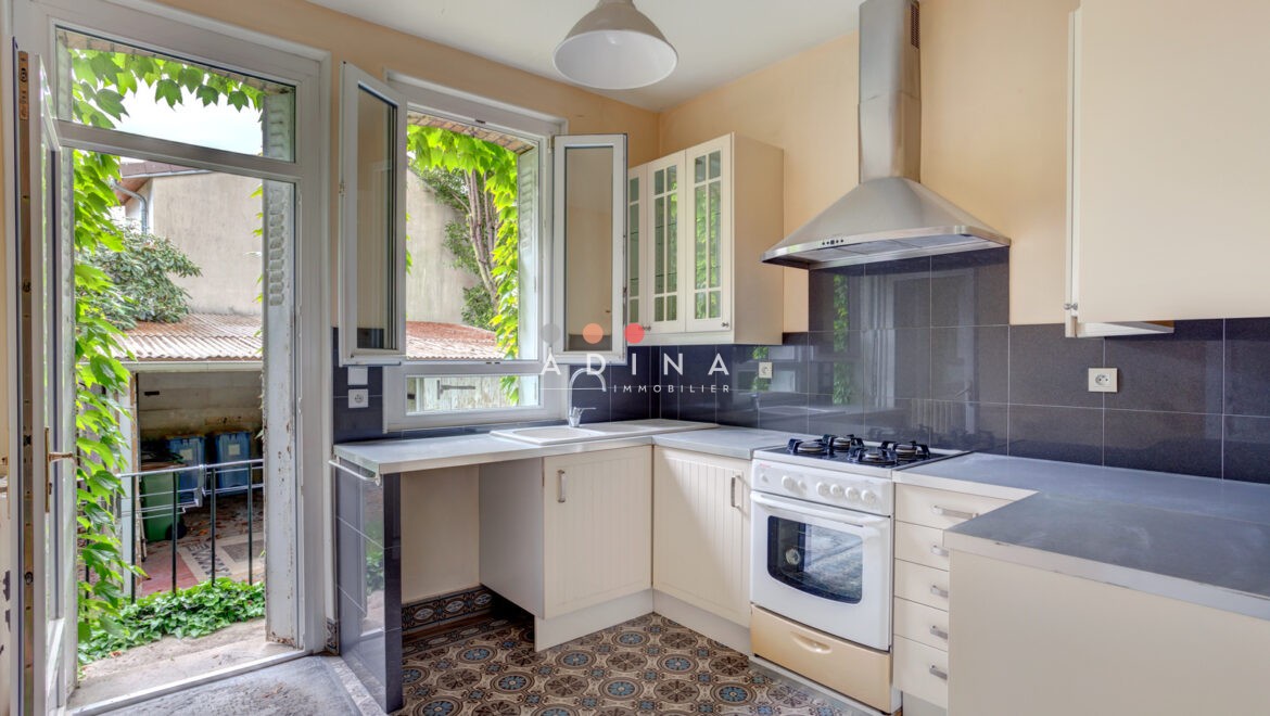 Cuisine lumineuse avec vue sur jardin verdoyant.