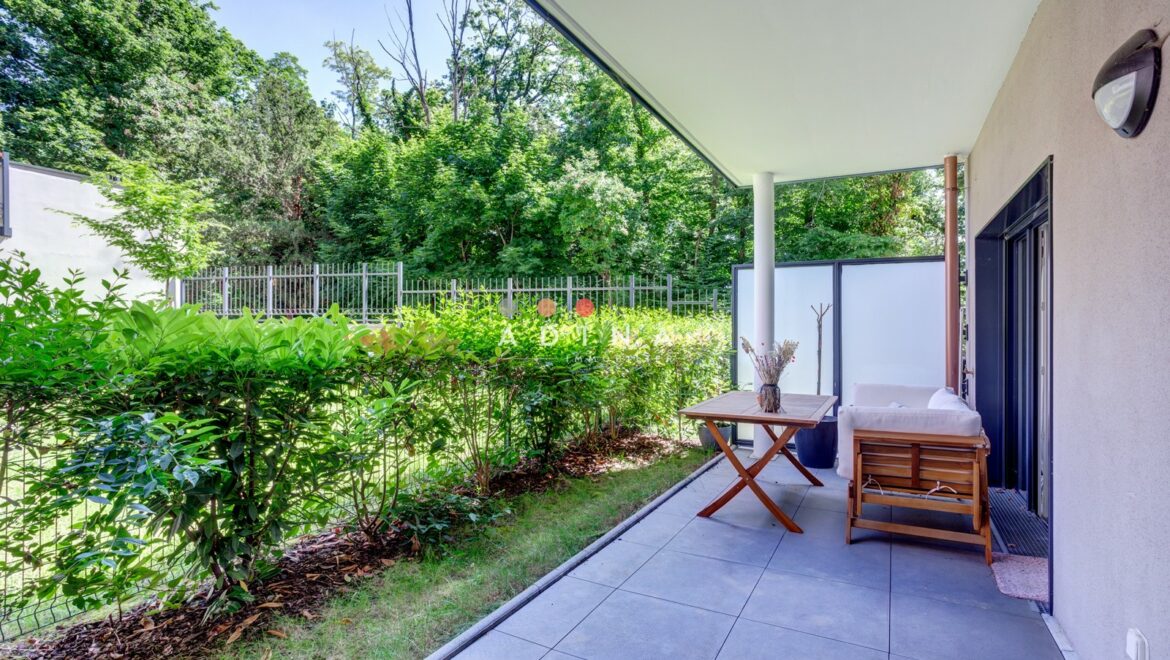 Terrasse avec mobilier en bois et haies verdoyantes au Plessis-Robinson.