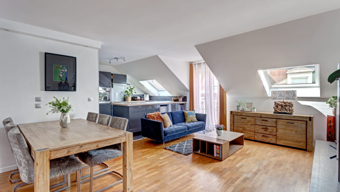 Salle de séjour moderne avec cuisine ouverte et grandes fenêtres.