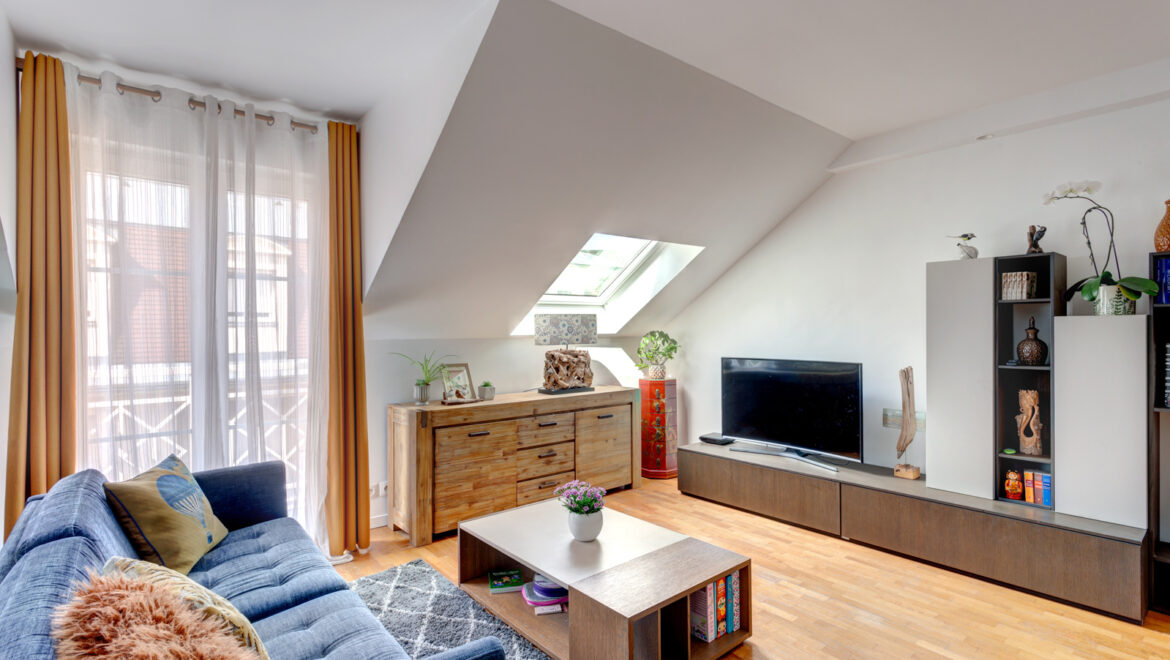 Salon moderne avec canapé bleu et meubles en bois.