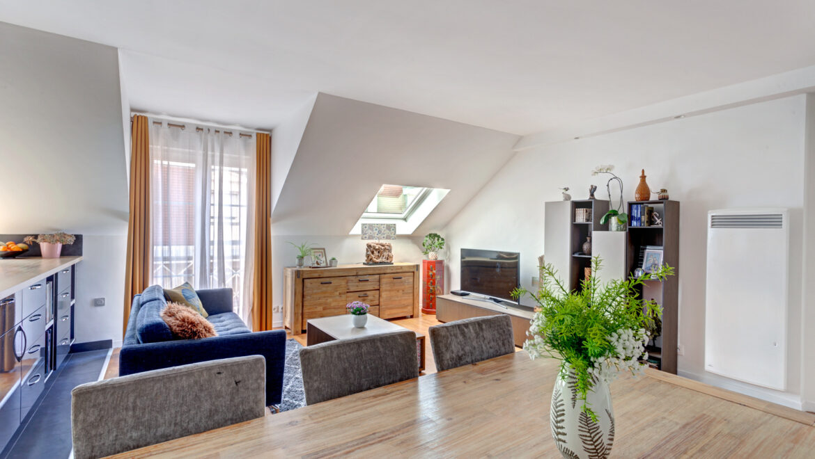 Salon moderne avec meubles en bois et canapé bleu.