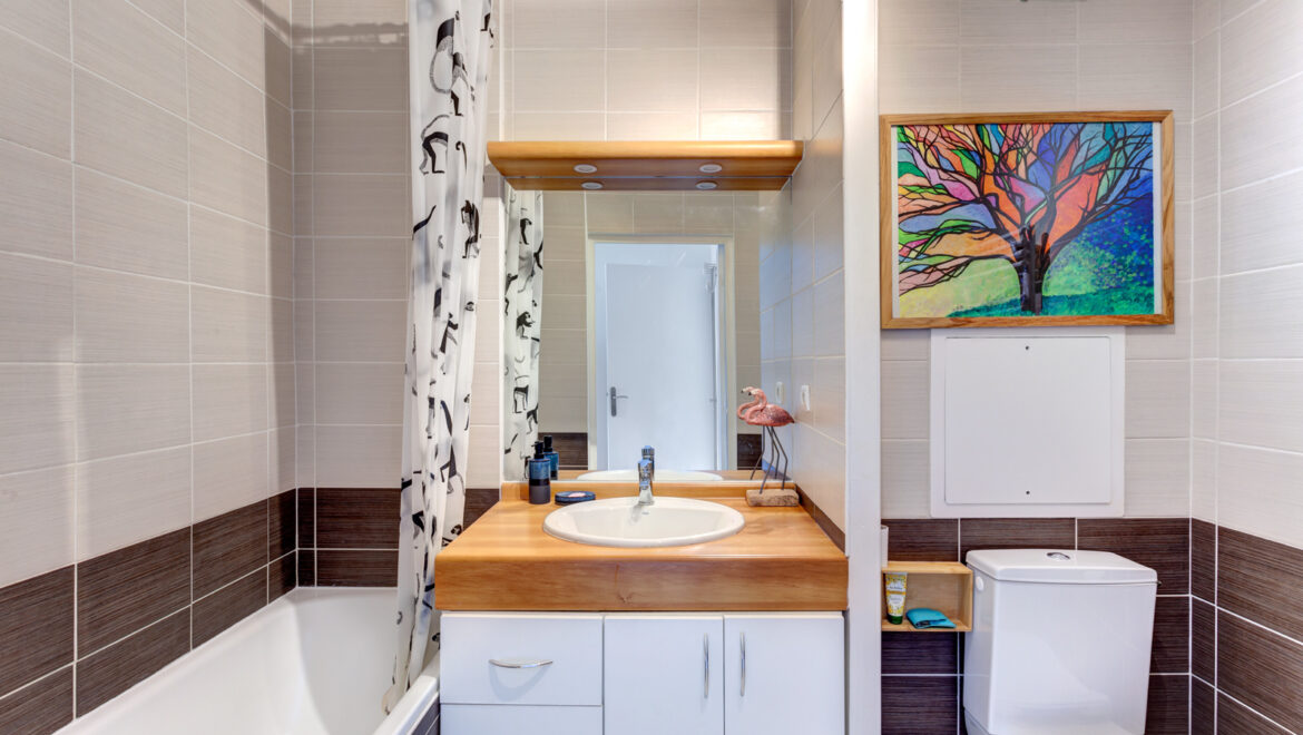 Salle de bains moderne avec baignoire et décoration colorée.