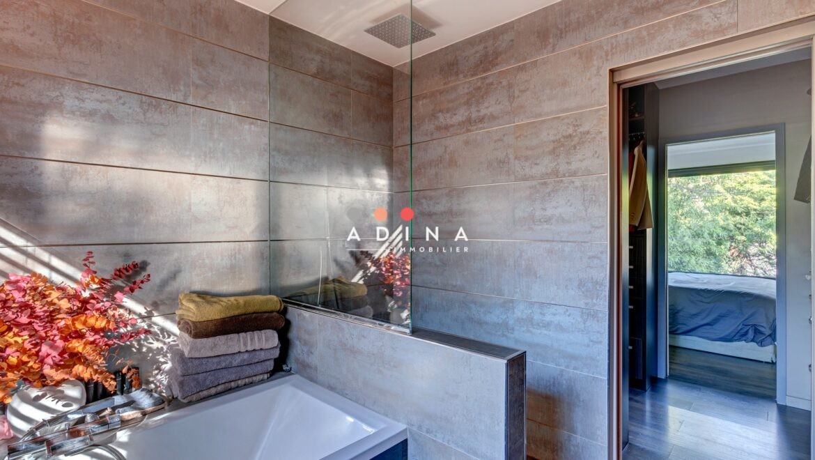 Salle de bain moderne avec baignoire et décor floral.