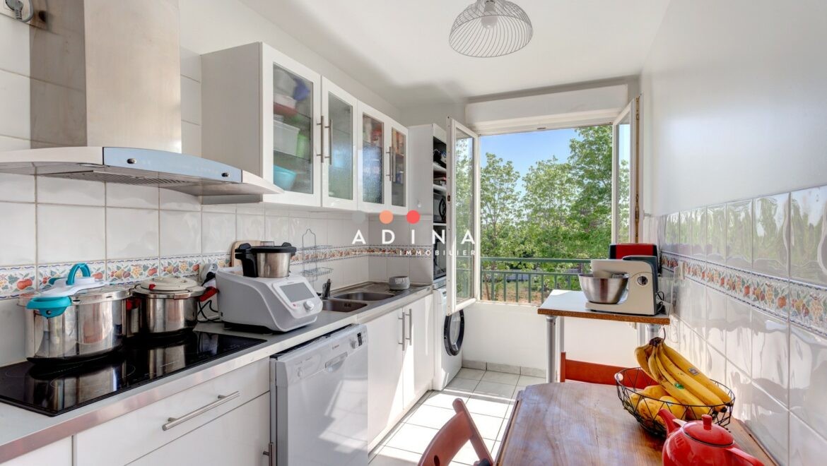 Cuisine lumineuse avec vue sur jardin au Plessis-Robinson.