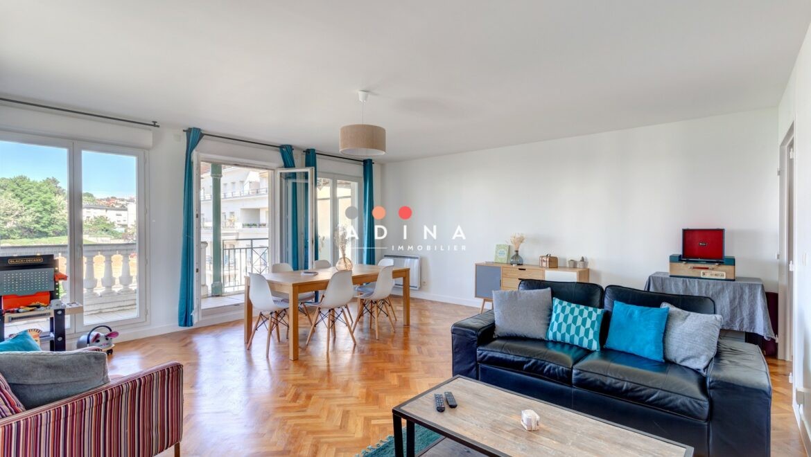 Appartement lumineux avec salon spacieux et parquet au sol.