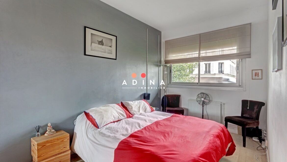 Chambre moderne avec lit double et fenêtre à Neuilly-sur-Seine.