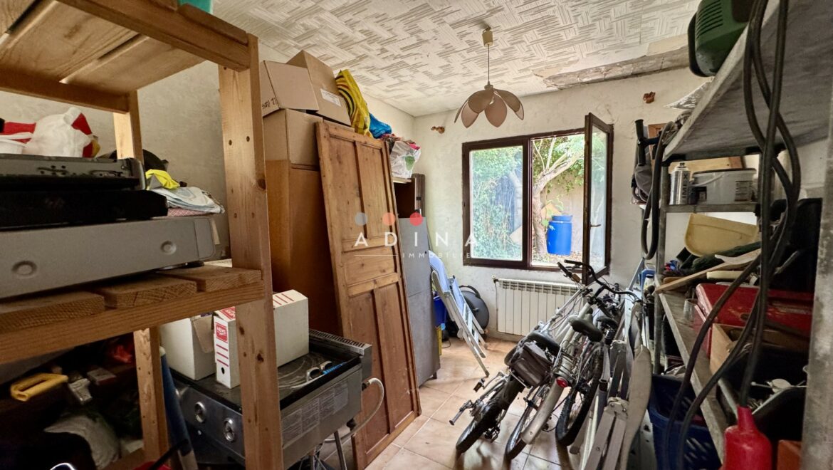Pièce de rangement encombrée avec vélos et étagères.