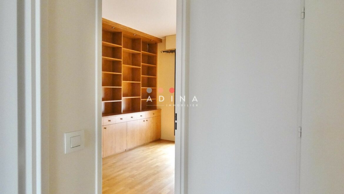 Salle avec étagères en bois et parquet au sol.