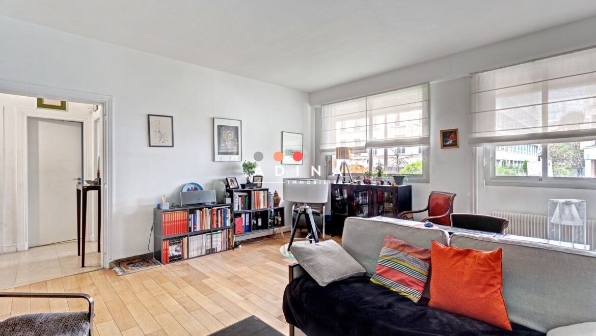 Salon moderne avec parquet et bibliothèque.