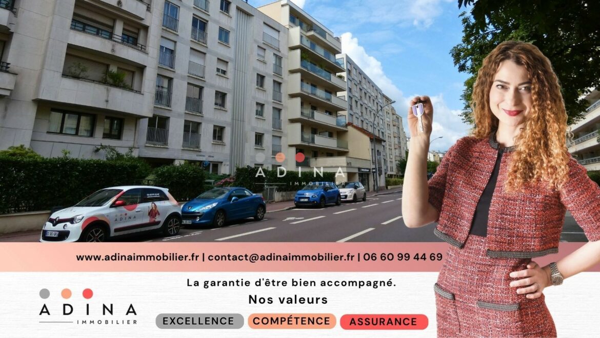 Homme tenant une clé devant un immeuble résidentiel.