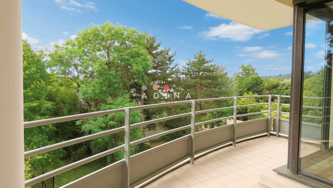 Balcon avec vue sur jardin verdoyant.
