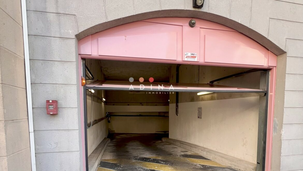 Entrée de parking souterrain avec porte ouverte.