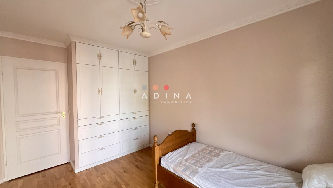 Chambre avec lit simple et placards intégrés.