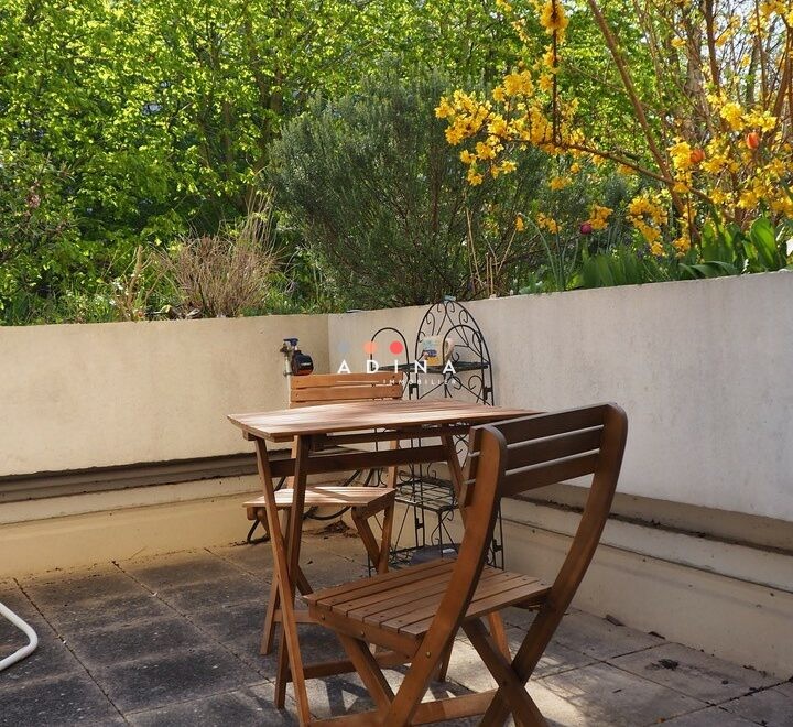 Terrasse ensoleillée avec table en bois à Nanterre.