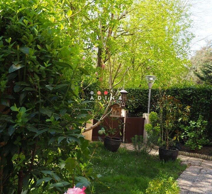 Jardin verdoyant avec fleurs roses à Nanterre.