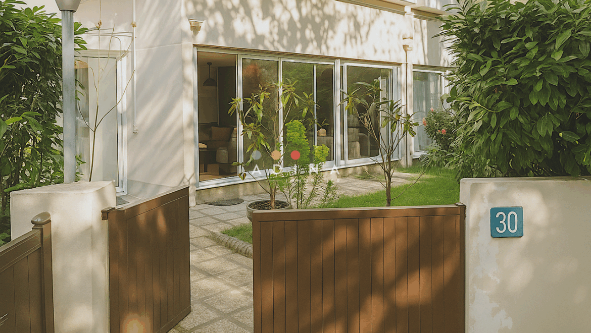 Façade d'une maison avec jardin et porte d'entrée.