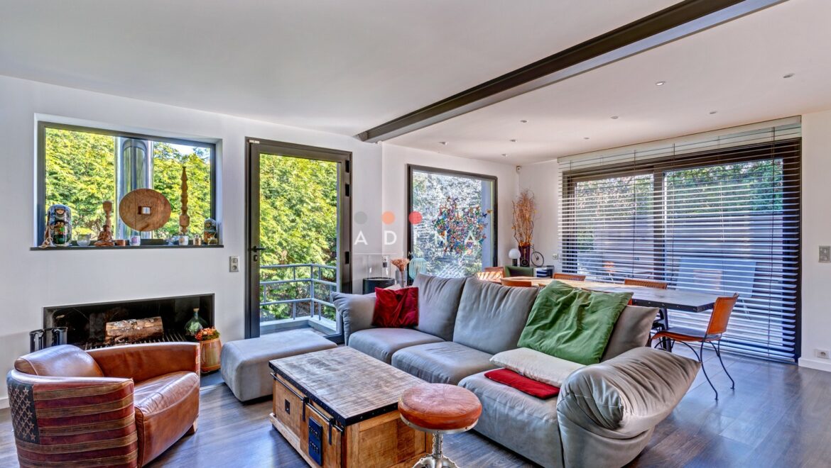 Salon moderne et lumineux avec vue sur la verdure.