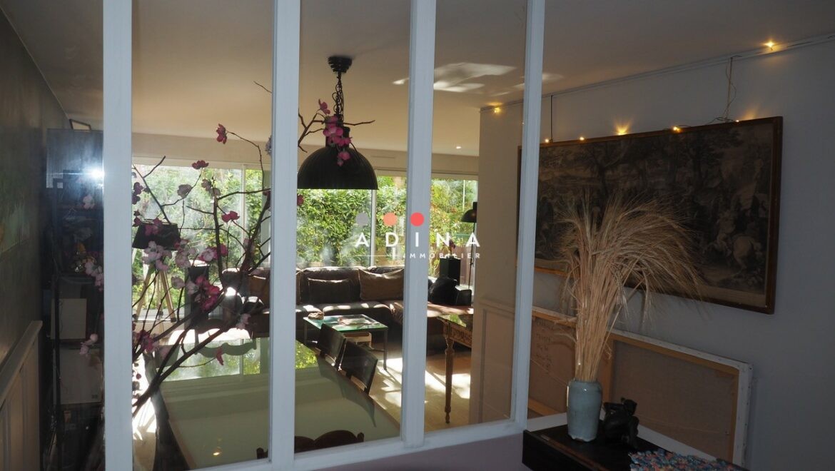 Intérieur lumineux avec décoration florale et baies vitrées à Nanterre.