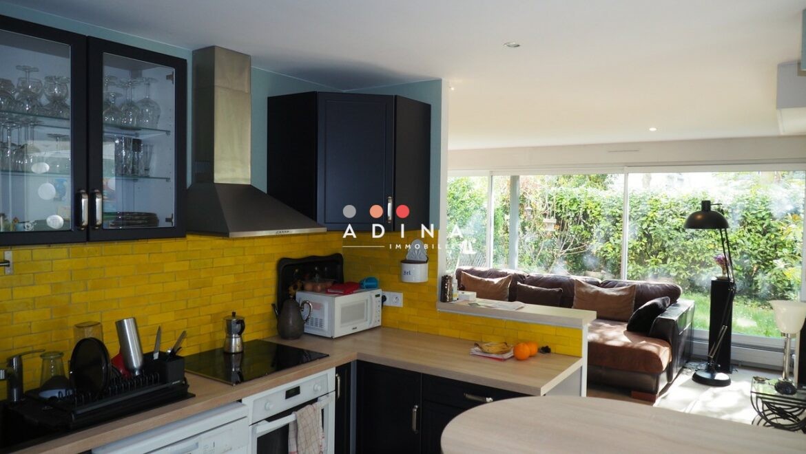 Cuisine ouverte avec salon et vue sur jardin à Nanterre.