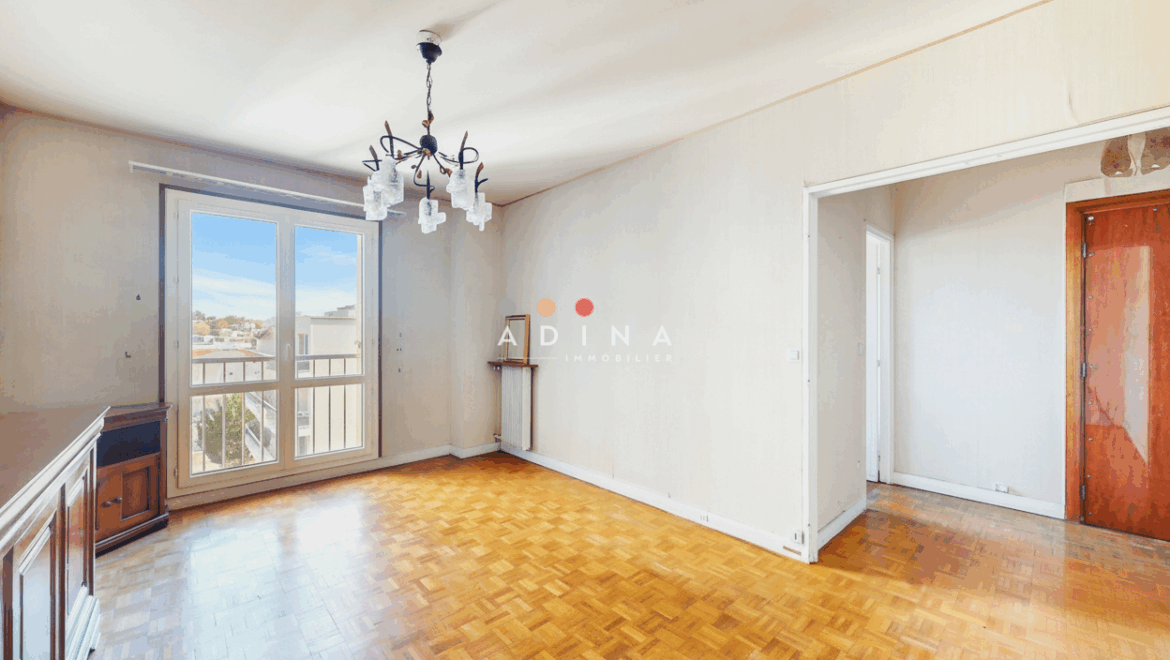 Salle de séjour lumineuse avec parquet.