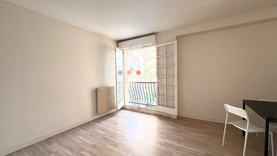 Appartement lumineux avec parquet et portes-fenêtres.