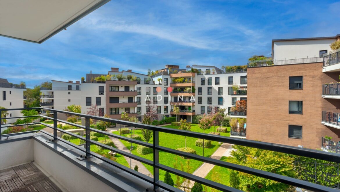 Vue depuis un balcon sur un complexe résidentiel moderne avec espaces verts.