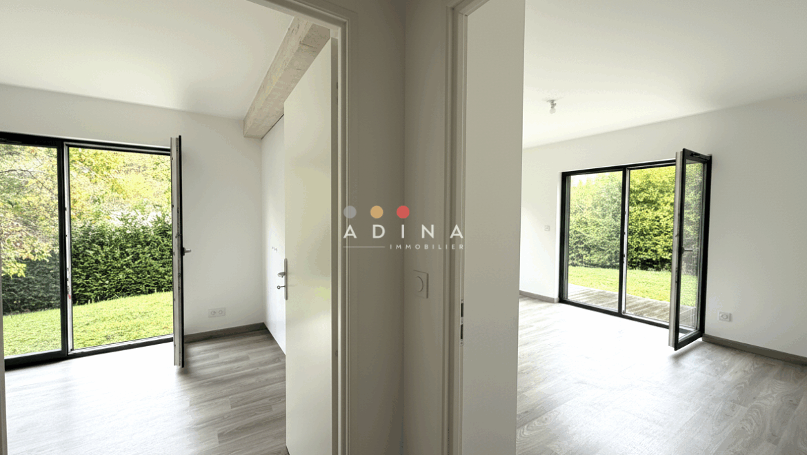 Deux pièces lumineuses avec portes vitrées donnant sur un jardin.