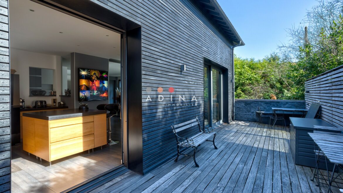 Terrasse en bois avec vue sur la cuisine moderne.
