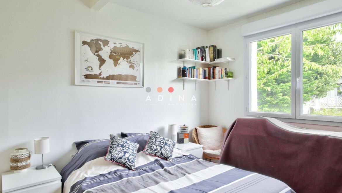 Chambre lumineuse avec lit et étagère murale.