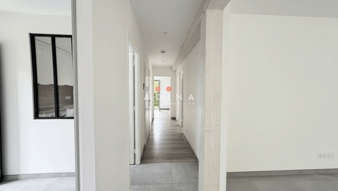 Couloir intérieur moderne avec parquet et carrelage.