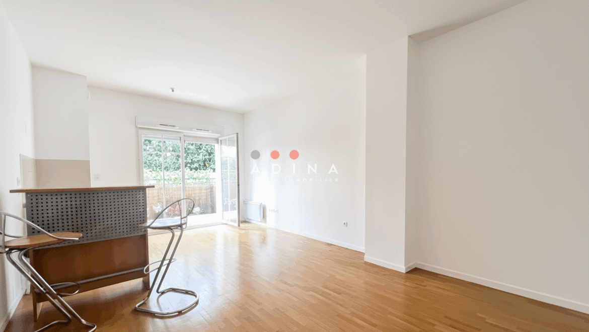Appartement lumineux avec parquet et baies vitrées.