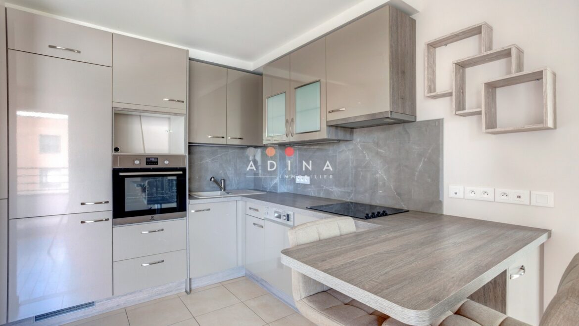 Cuisine moderne avec placards beige et bar, Le Plessis-Robinson.