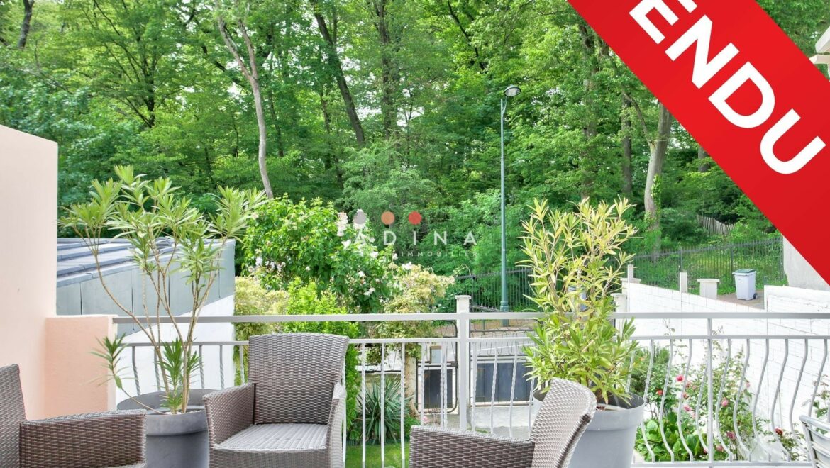 Terrasse avec mobilier en rotin, étiquette "Vendu".