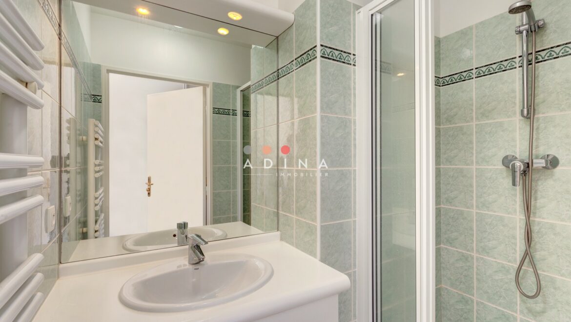 Salle de bain moderne avec douche et lavabo.