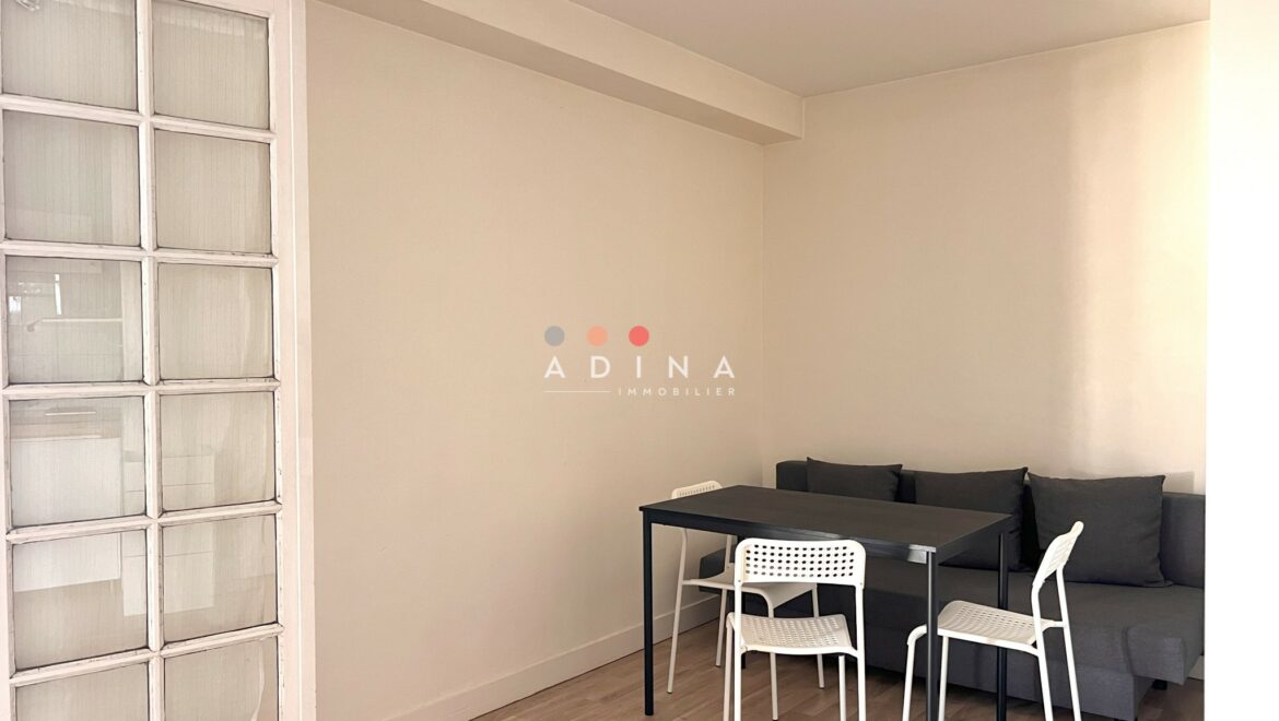 Salle à manger minimaliste avec table, chaises et canapé.