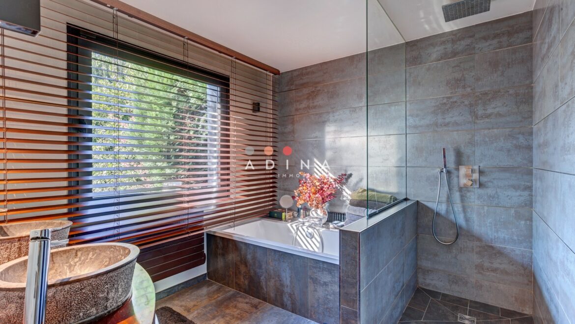 Salle de bain moderne avec baignoire et douche italienne.