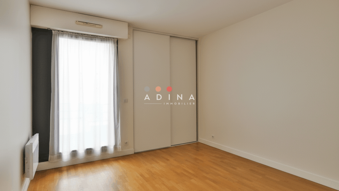 Chambre vide avec parquet et placard intégré.