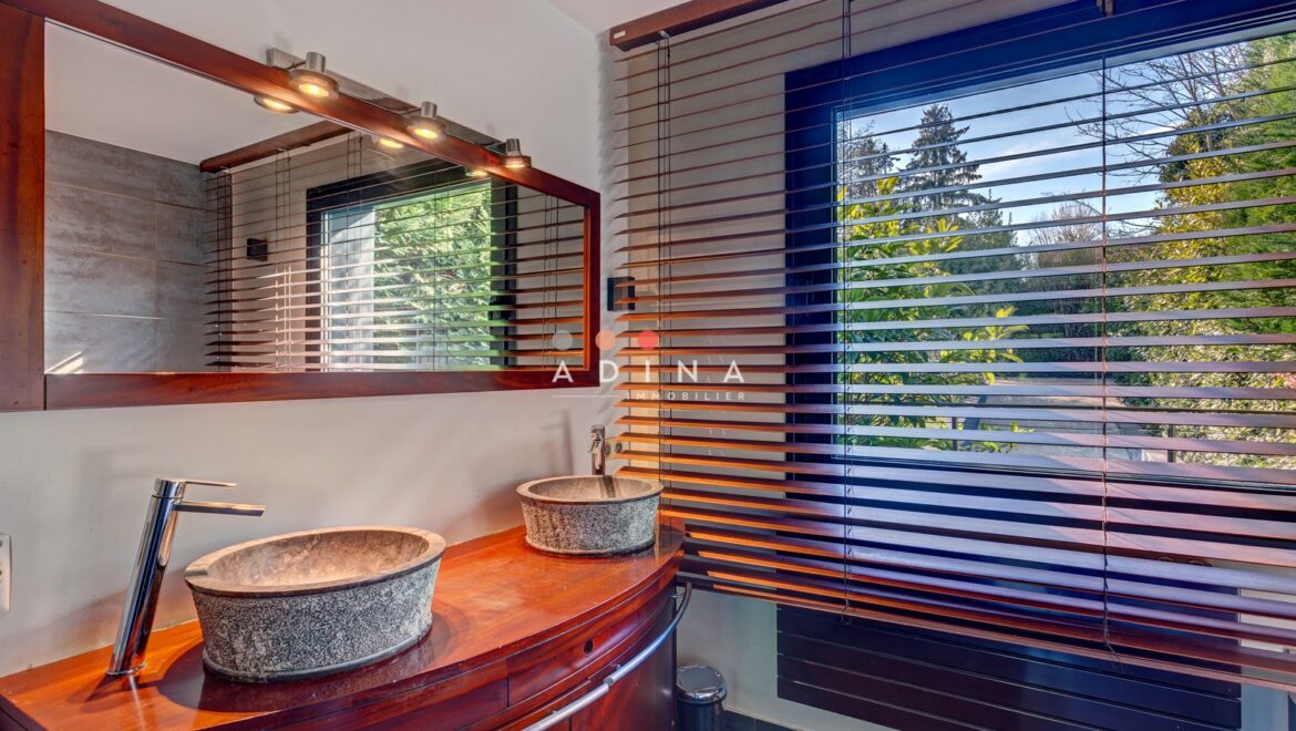 Salle de bain moderne avec deux lavabos et grande fenêtre.
