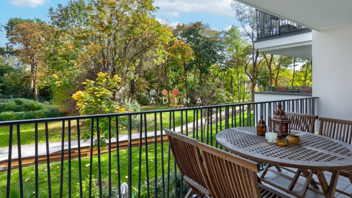Balcon avec vue sur un jardin verdoyant.