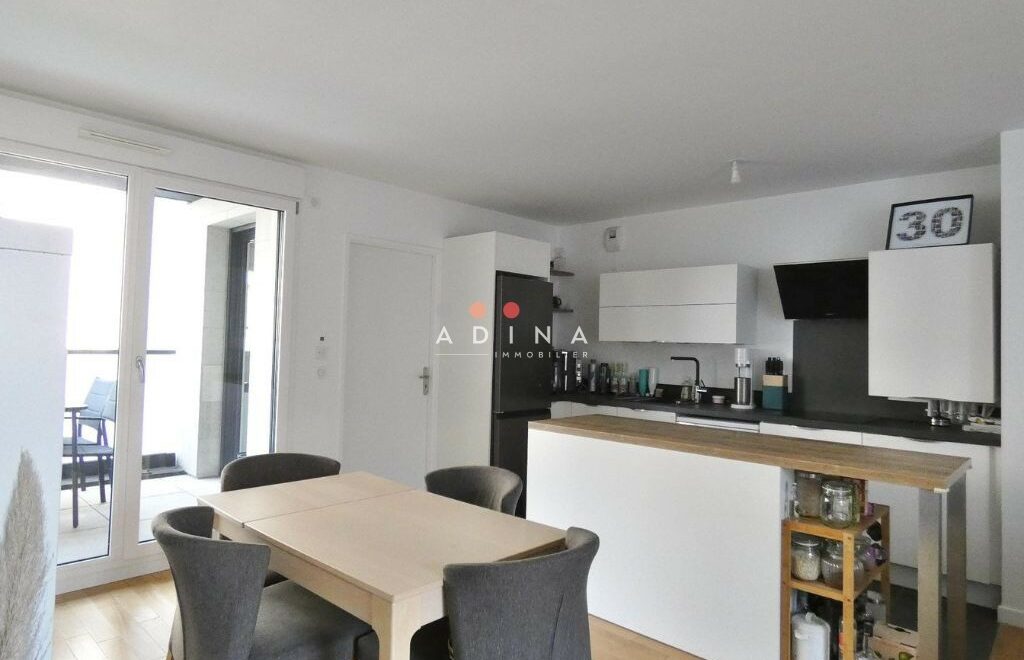 Salon moderne avec cuisine ouverte.