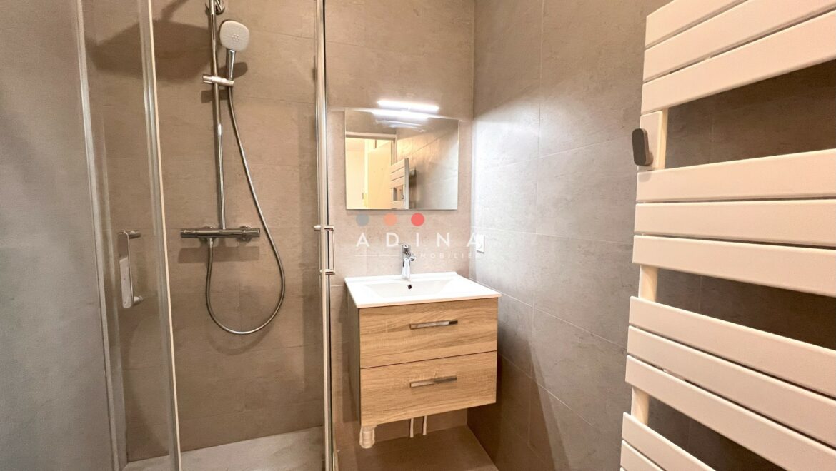 Salle de bain moderne avec douche à l'italienne et lavabo suspendu.
