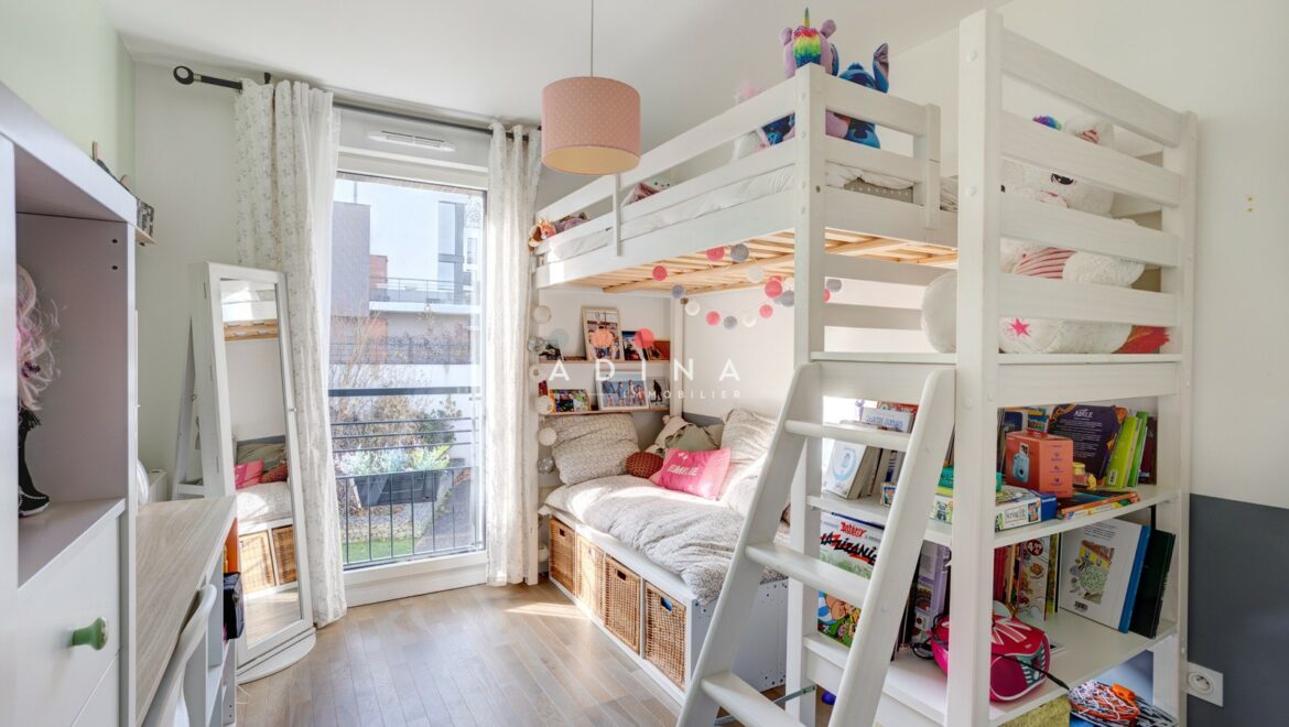 Chambre d'enfant avec lit superposé et rangements.
