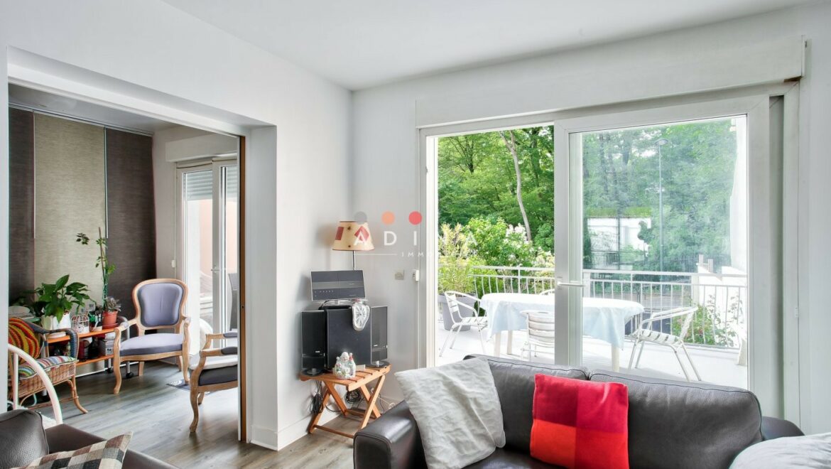 Intérieur lumineux avec salon et terrasse verdoyante.