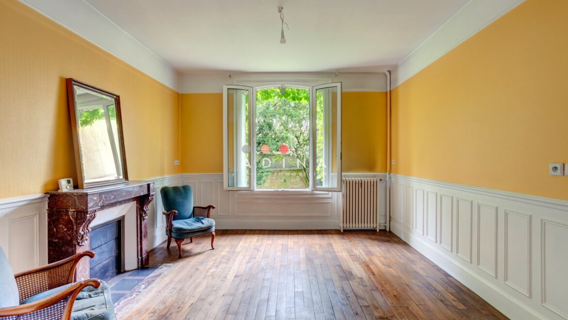 Salon lumineux avec murs jaunes et cheminée.