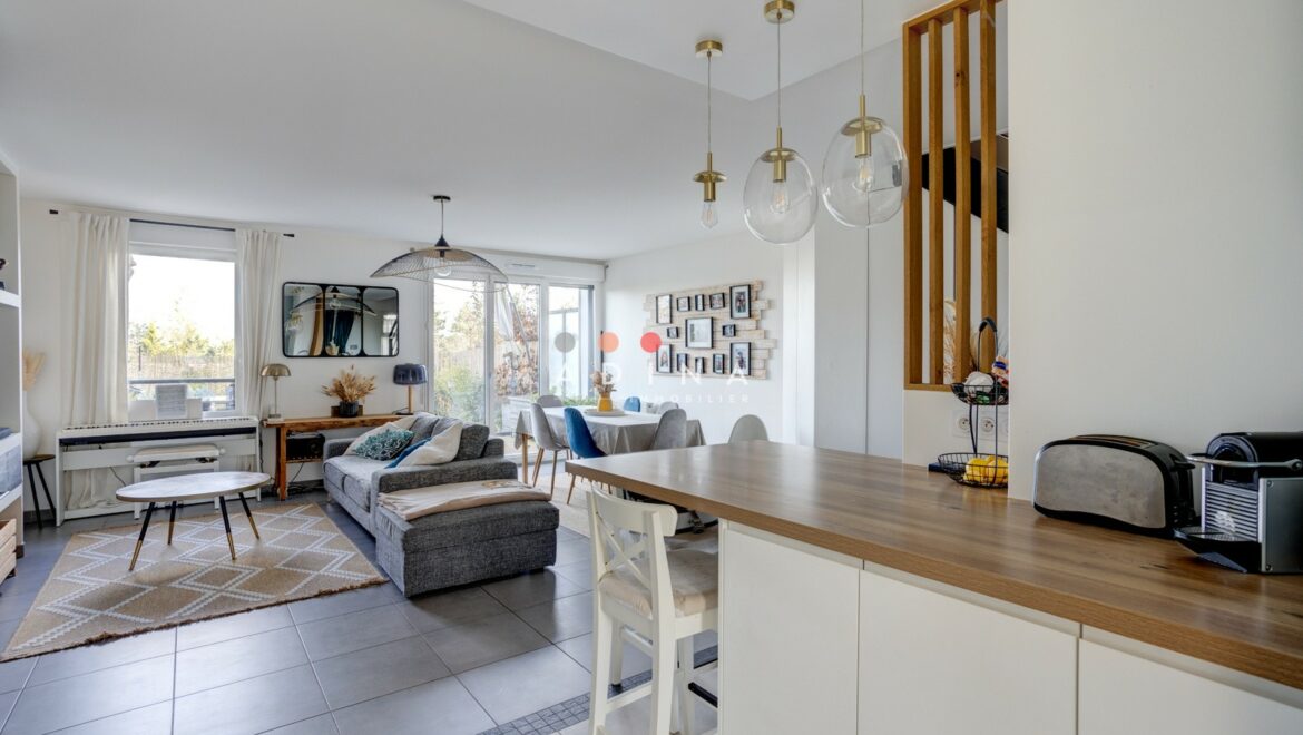 Salon moderne et lumineux avec coin cuisine.