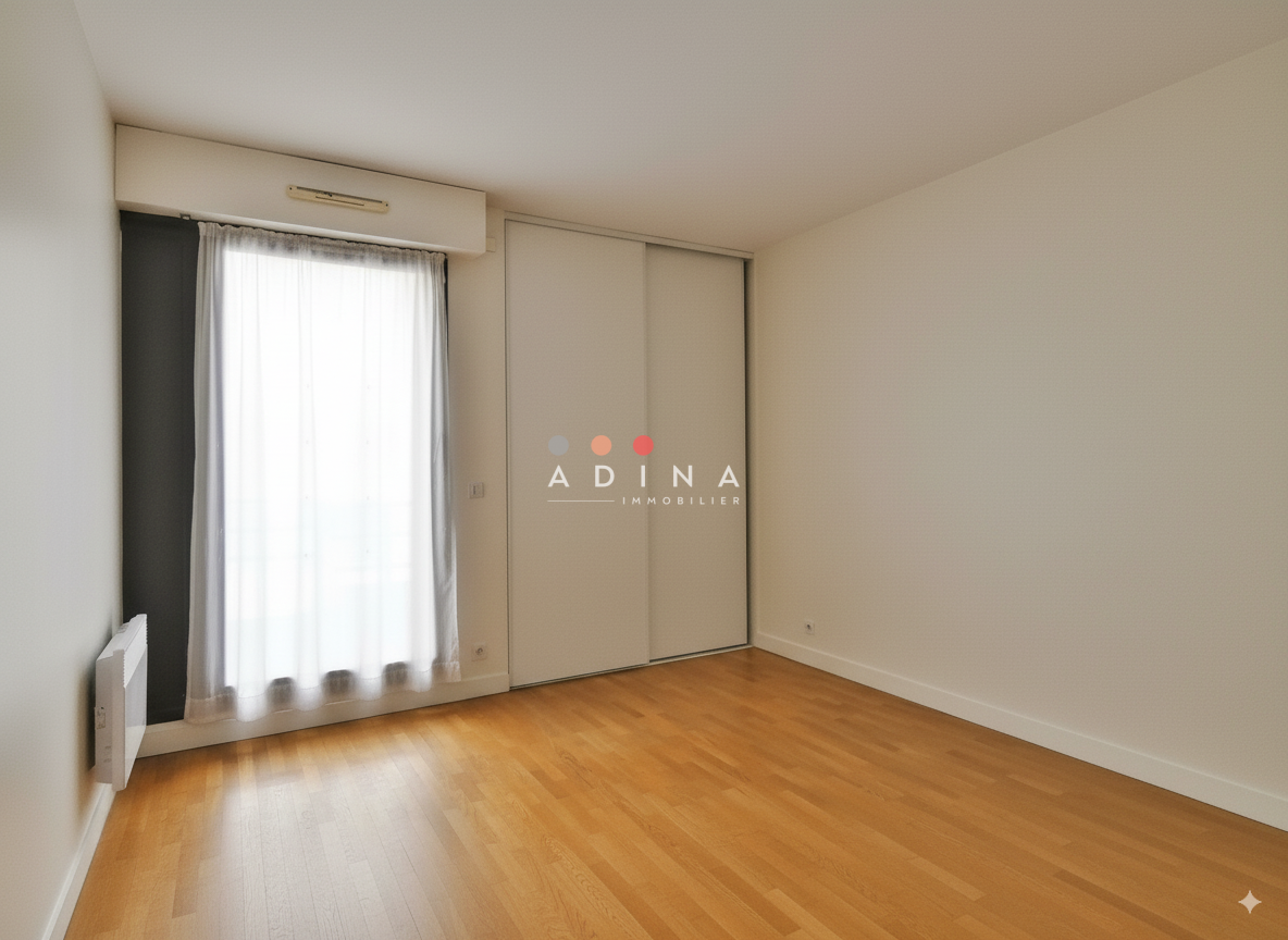 Chambre vide avec parquet et grande fenêtre.