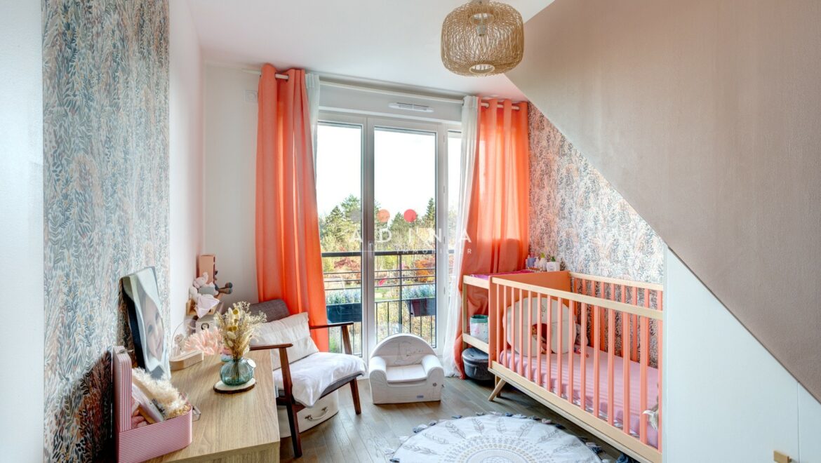 Chambre d'enfant lumineuse avec lit bébé et décor coloré.