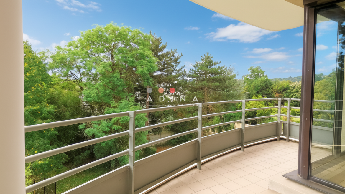 Balcon avec vue sur des arbres et le ciel.